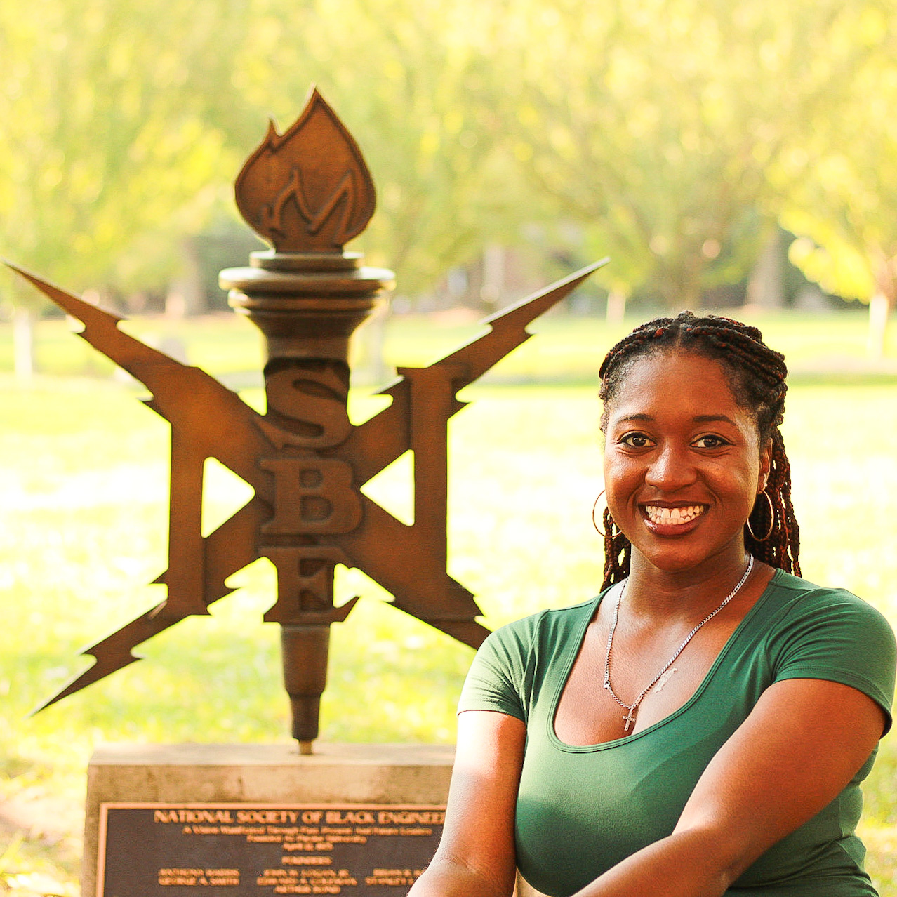 National Society of Black Engineers member standing infront of the NSBE sign