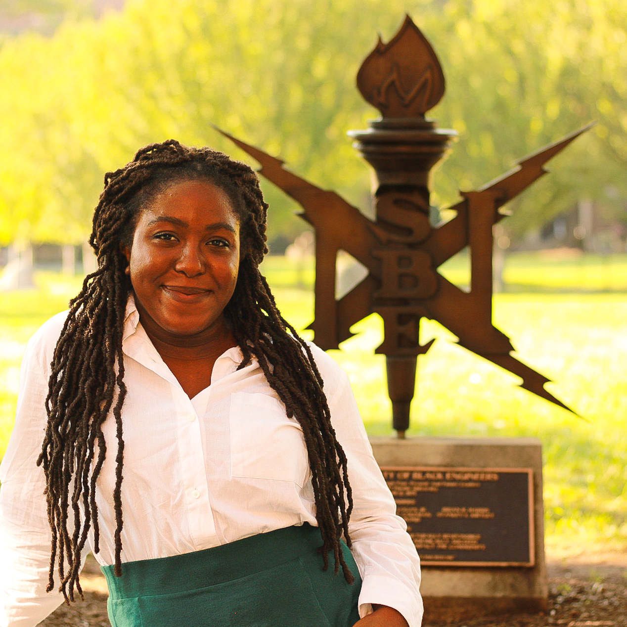 National Society of Black Engineers member standing infront of the NSBE sign