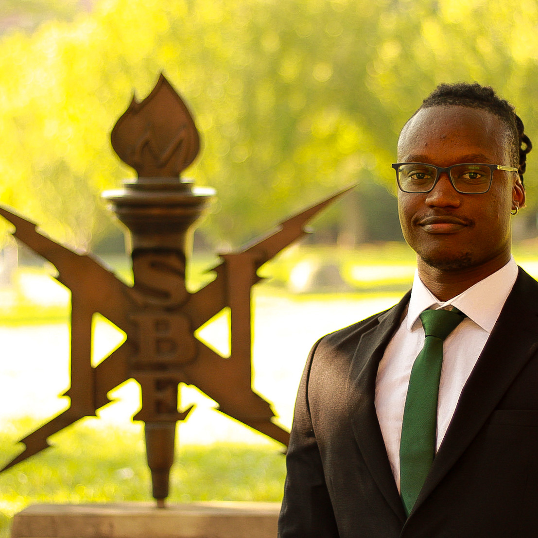 National Society of Black Engineers member standing infront of the NSBE sign