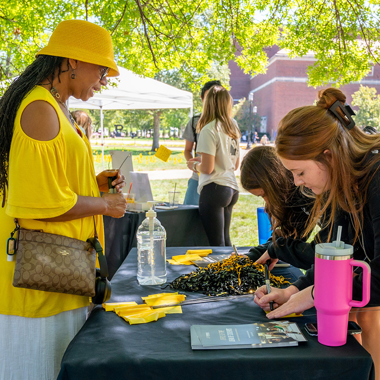 CAPS staff meeting with students at an outdoor event